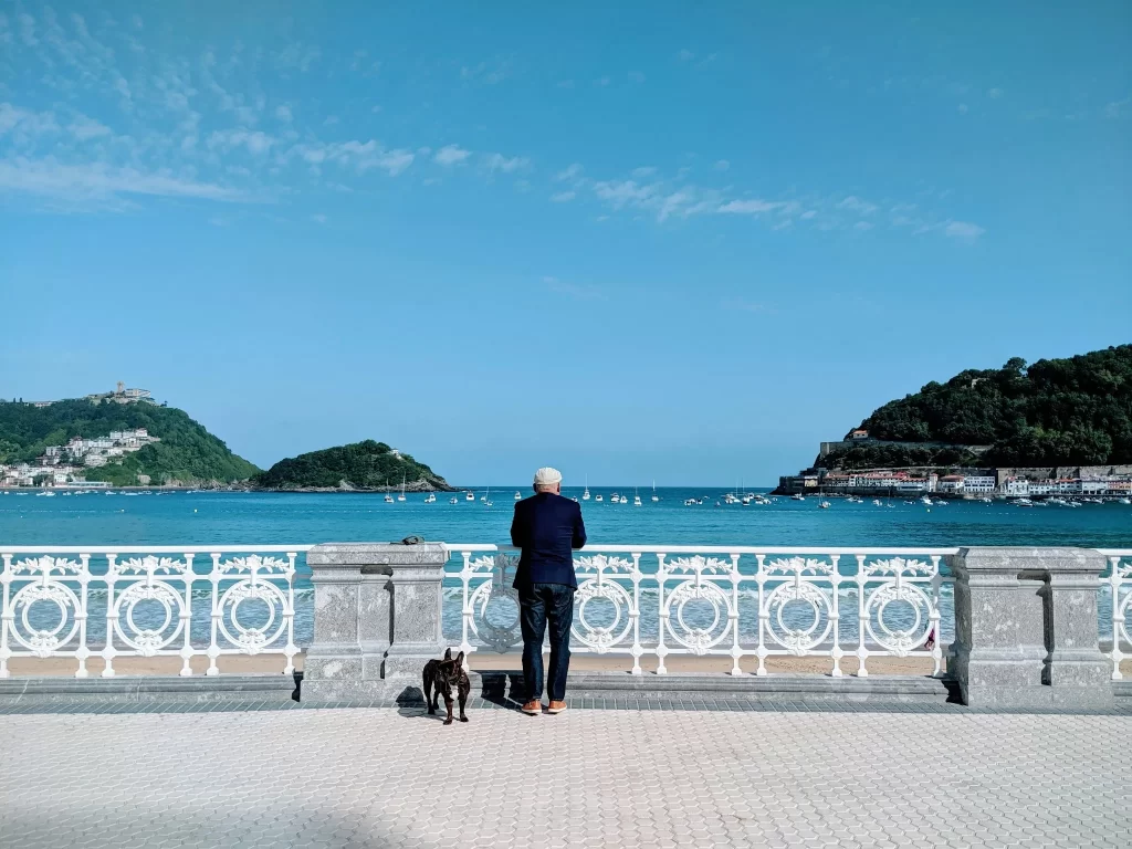 Homme avec un chien contemplant la baie de la Concha à San Sebastian