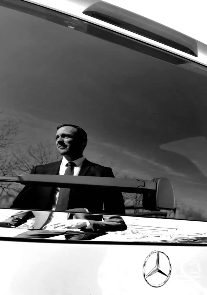 Passionate chauffeur reflecting on a high end vehicle to illustrate a chauffeur service in Biarritz