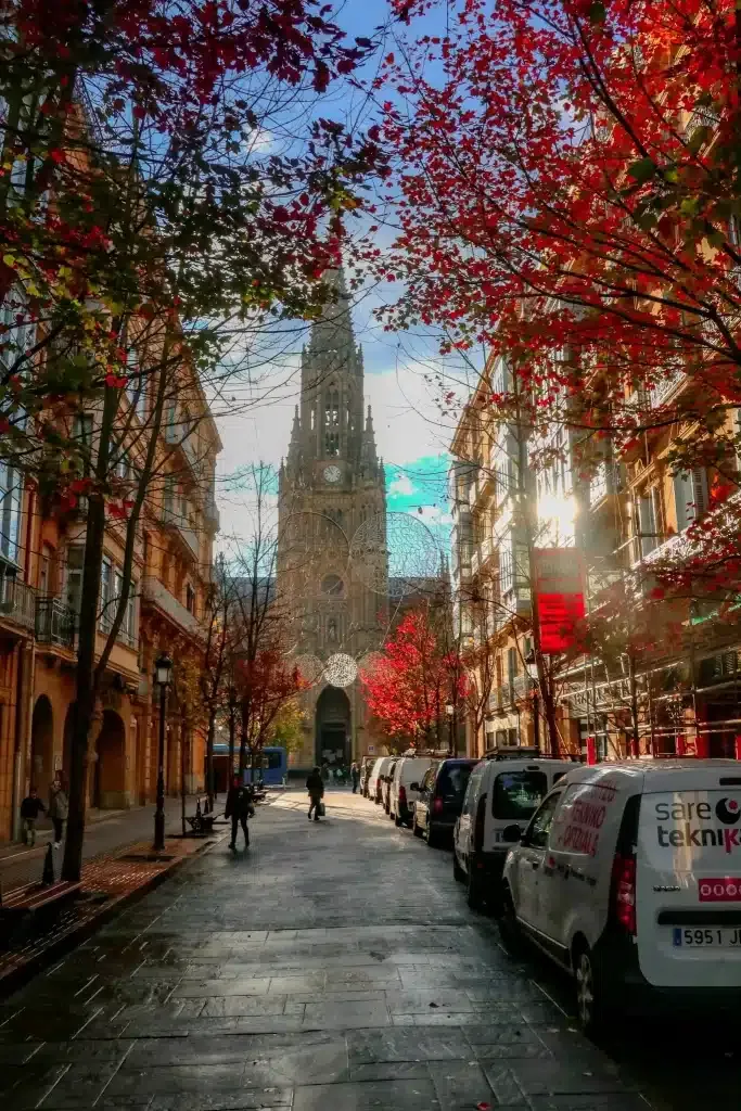 Exterior view of Buen Pastor Church surrounded by autumn trees in San Sebastian