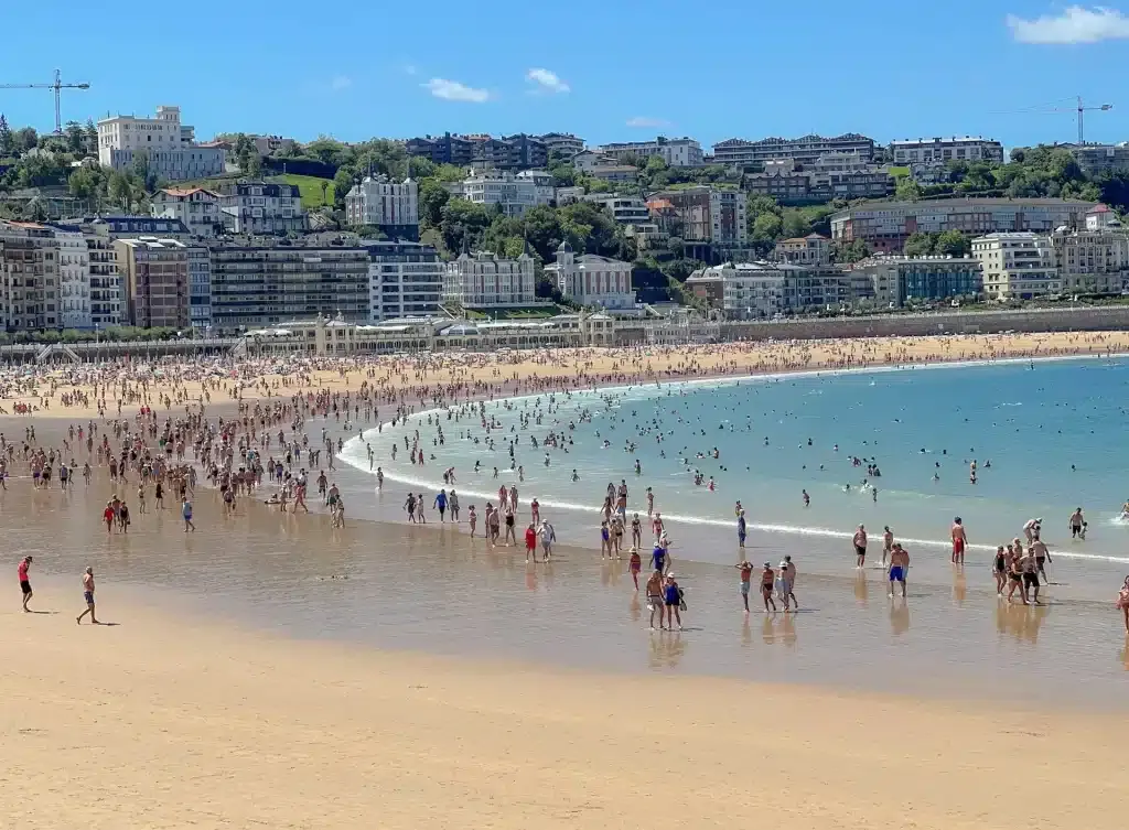 A sunny day at La Concha Beach with people enjoying the sand and water in San Sebastian