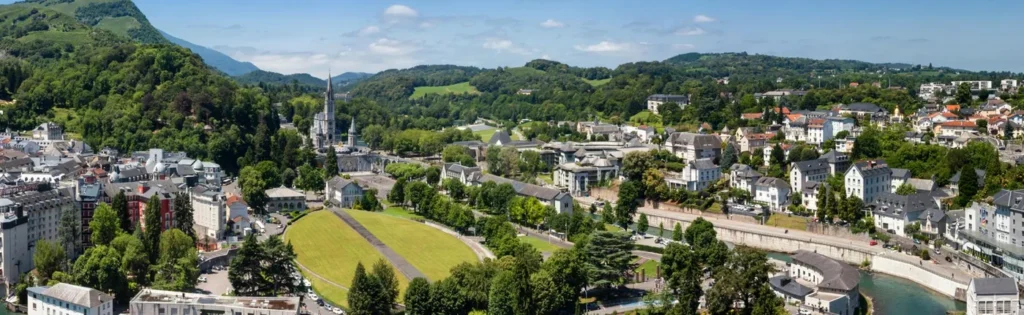 Biarritz to Lourdes taxi – aerial panoramic view of Lourdes city and sanctuary with Pyrenees